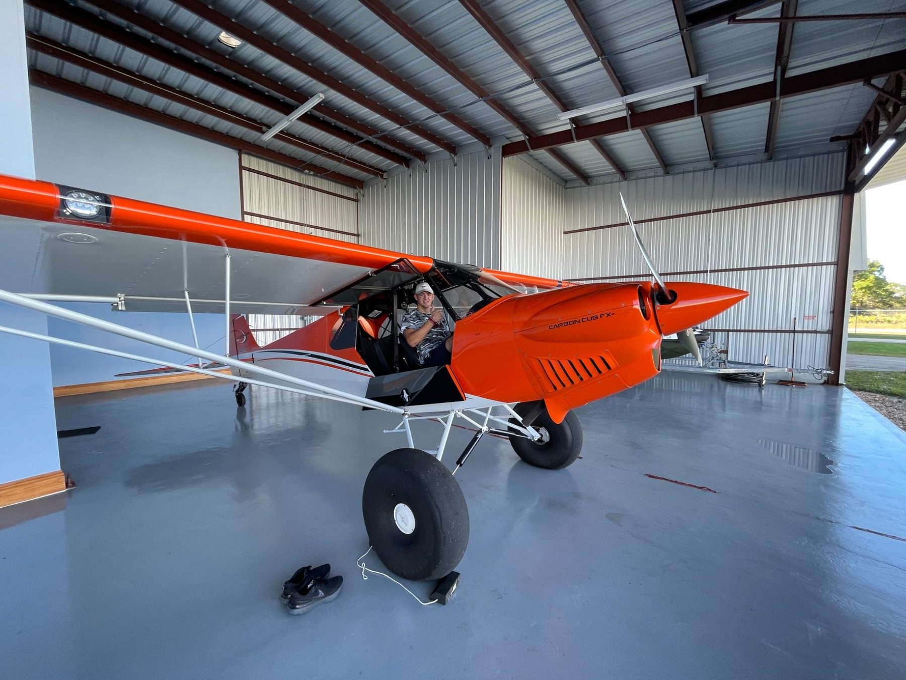 Orange Carbon Cub taildragger in hangar